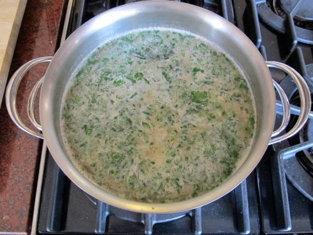Broth and vegetables simmering in a stockpot.